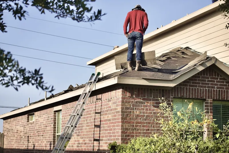 Professional roofer working on a residential roof in Kinsman Corner